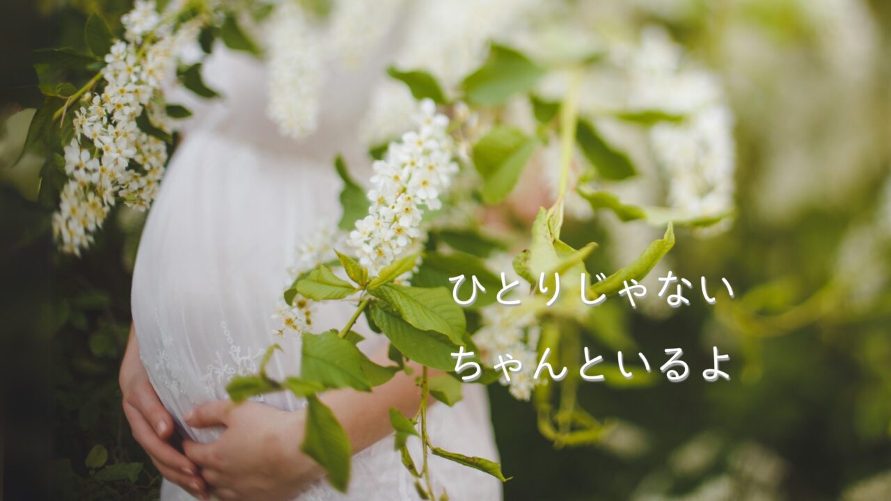 白い花と妊婦さんの手元に寄り添うあたたかい写真。“ひとりじゃない　ちゃんといるよ”の文字入り