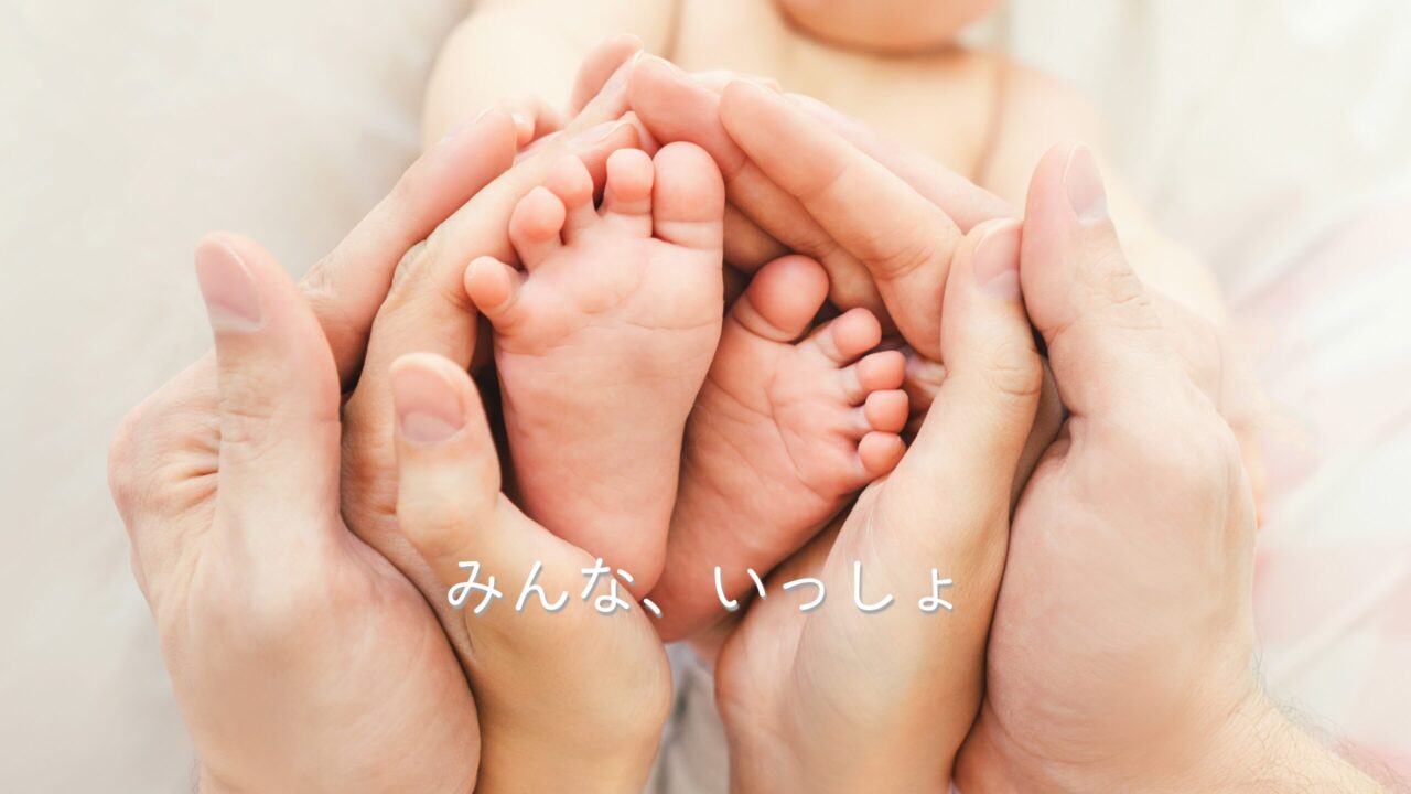 赤ちゃんの足を囲む家族の手。やさしさに包まれる姿