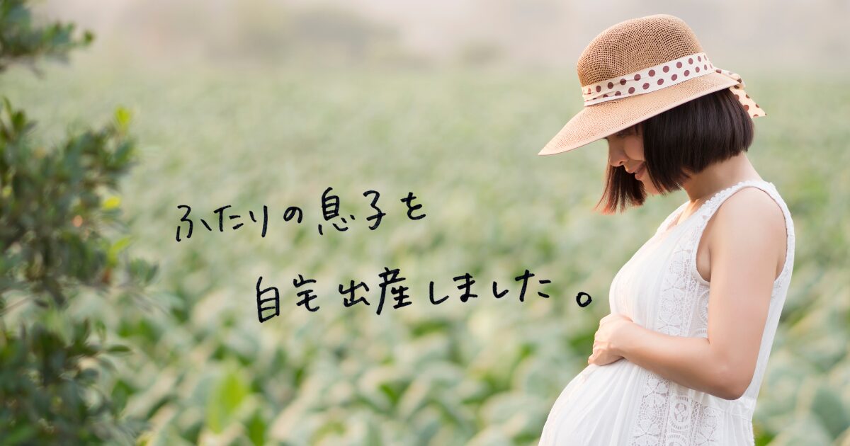 緑の畑を背景に、妊娠中のお腹にそっと手を添える女性のイメージ画像